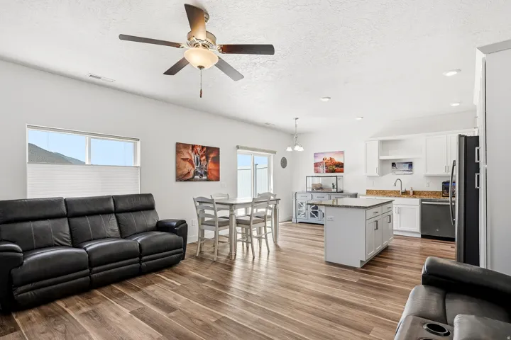 Spacious open-concept living area featuring wood-finish flooring, recessed lighting, and a ceiling fan