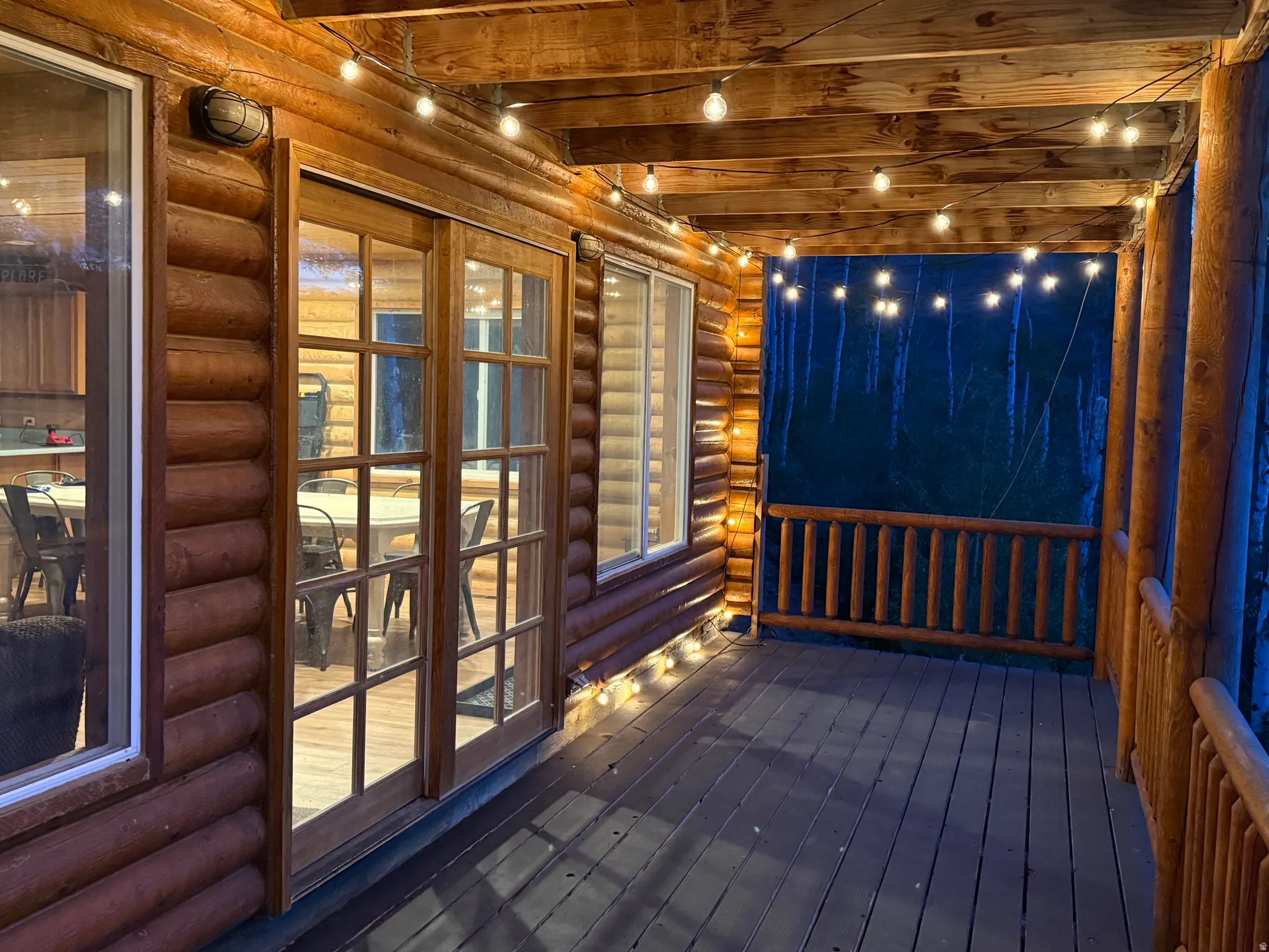 Wood-finish deck with log siding and exposed beam ceiling