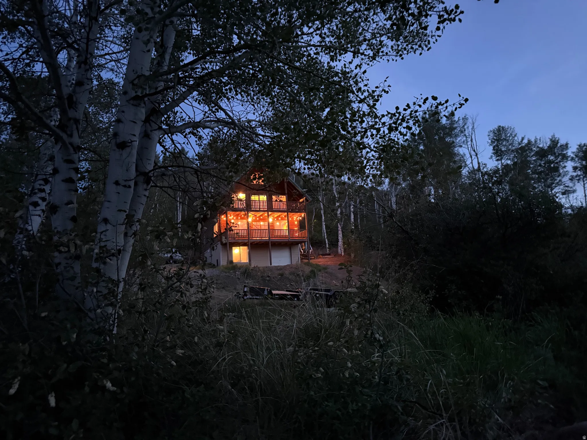 Wood-sided structure featuring multiple large windows and an expansive upper-level balcony