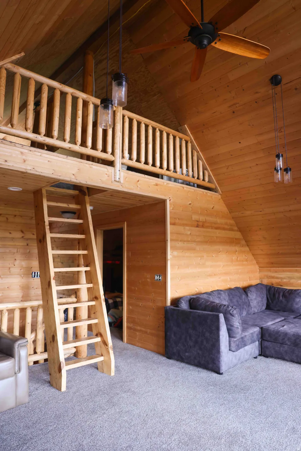 Light wood-finish paneling and exposed beam ceiling with a ceiling fan
