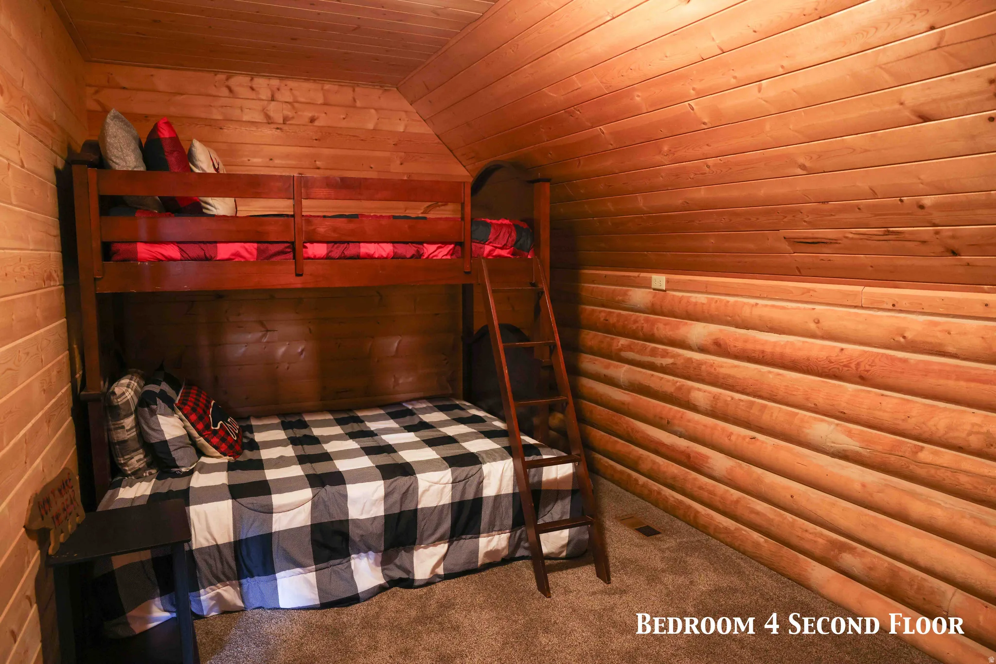 Attic bedroom featuring natural wood plank walls, a vaulted wood plank ceiling, and carpeted flooring