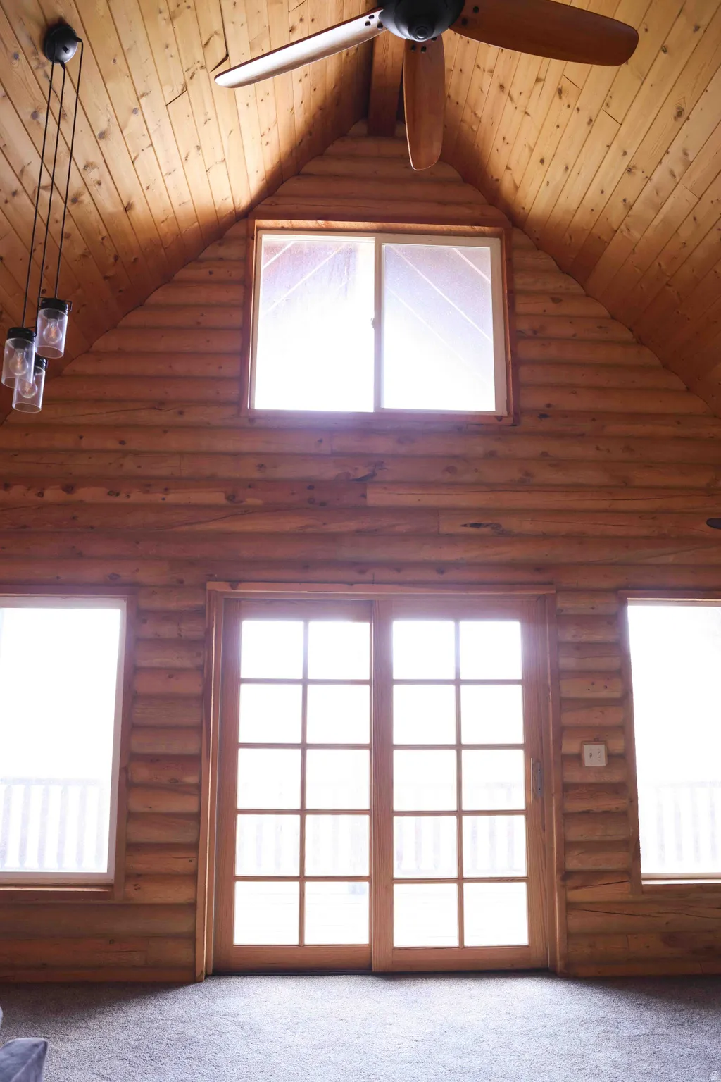 Vaulted wood-paneled ceiling with an exposed beam, featuring a ceiling fan