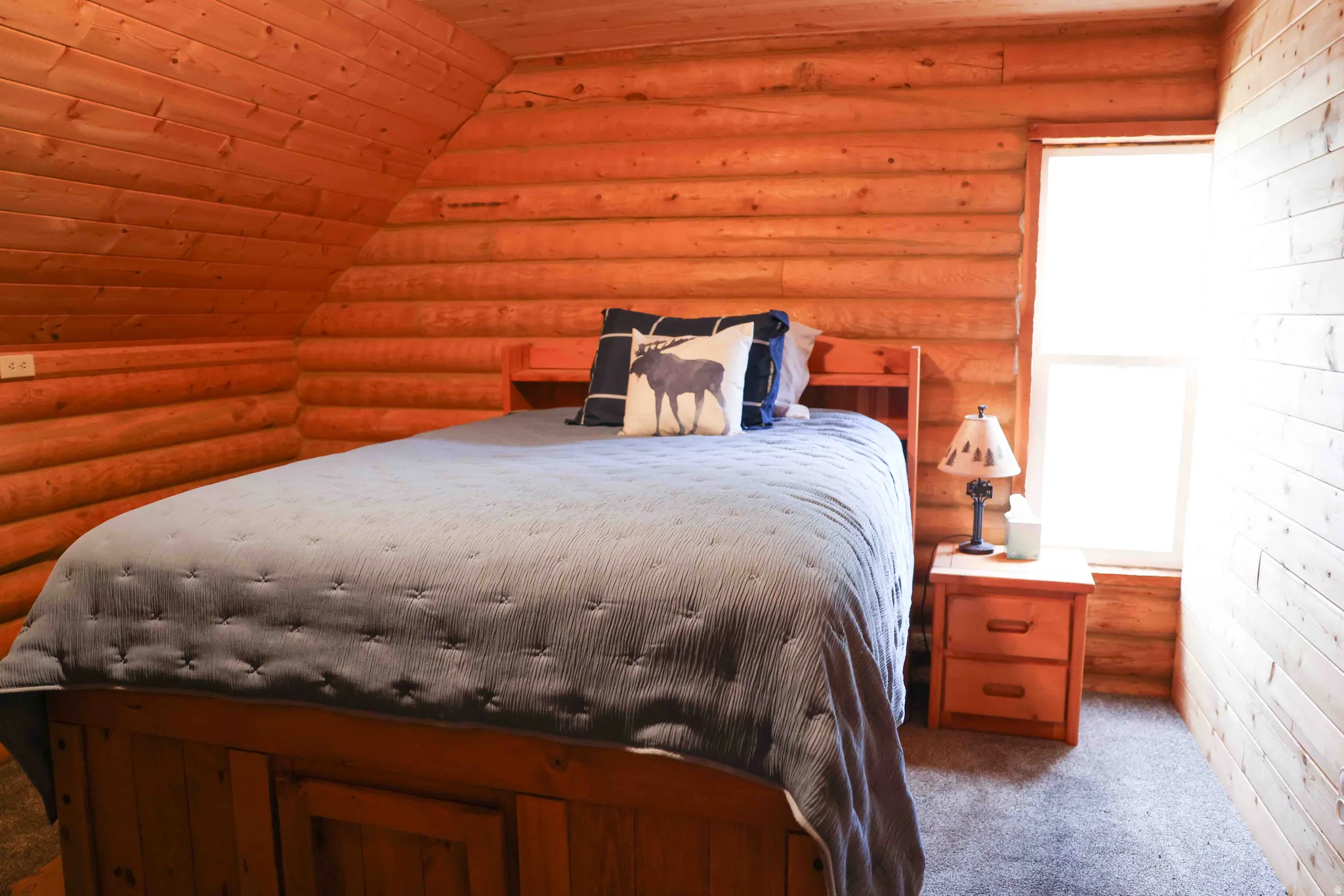 Wood-paneled room featuring a sloped ceiling and a single window