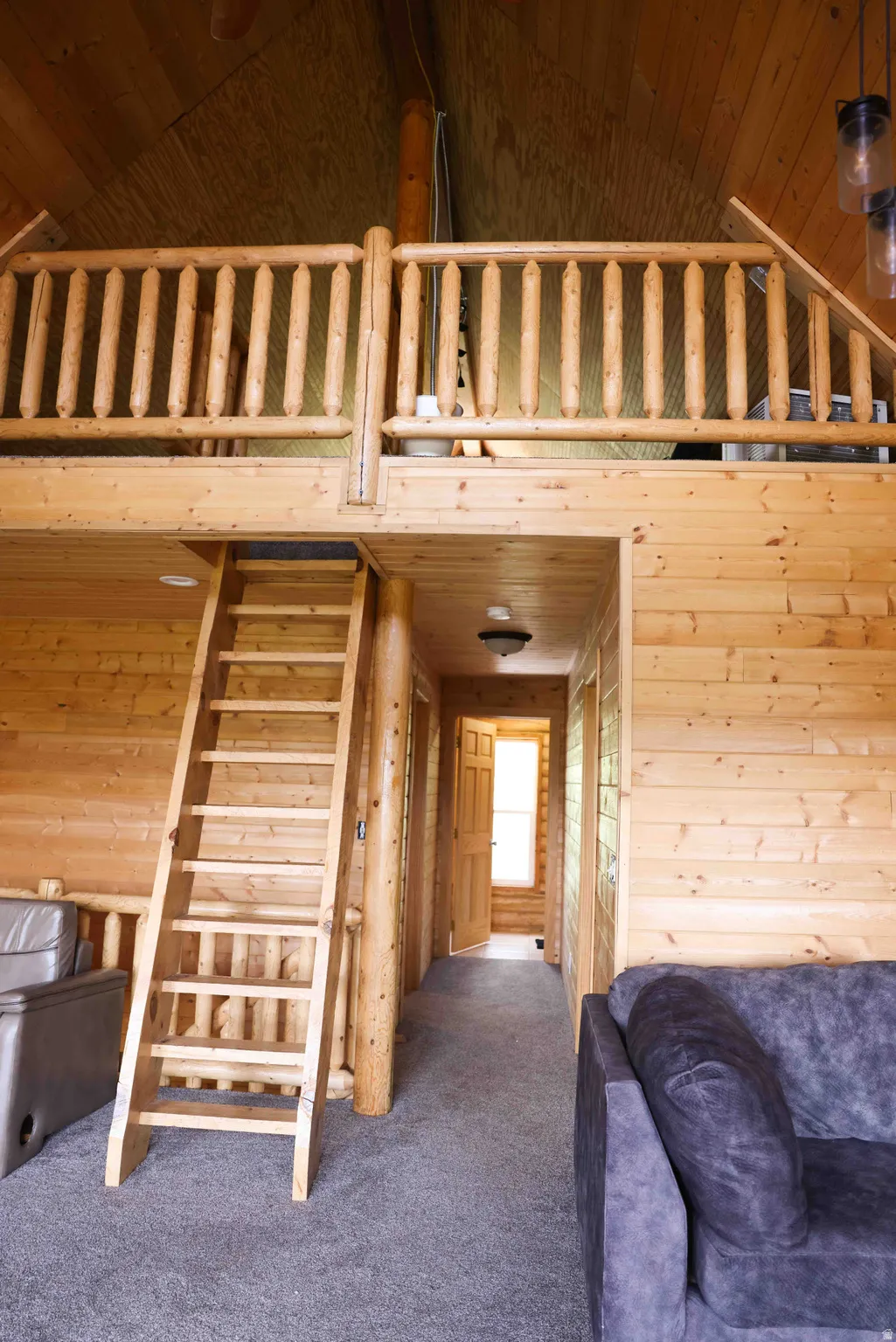 Interior featuring wood plank walls, exposed wood ceiling, and gray carpeting