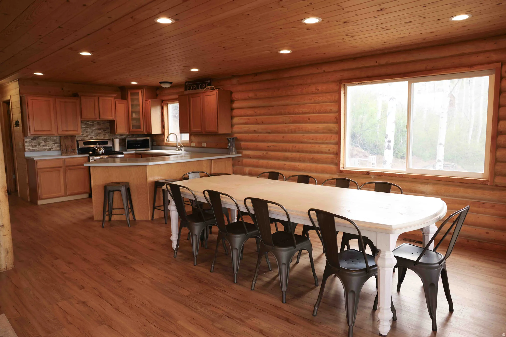 Expansive open-concept room featuring wood-finish flooring, recessed lighting, and a large window