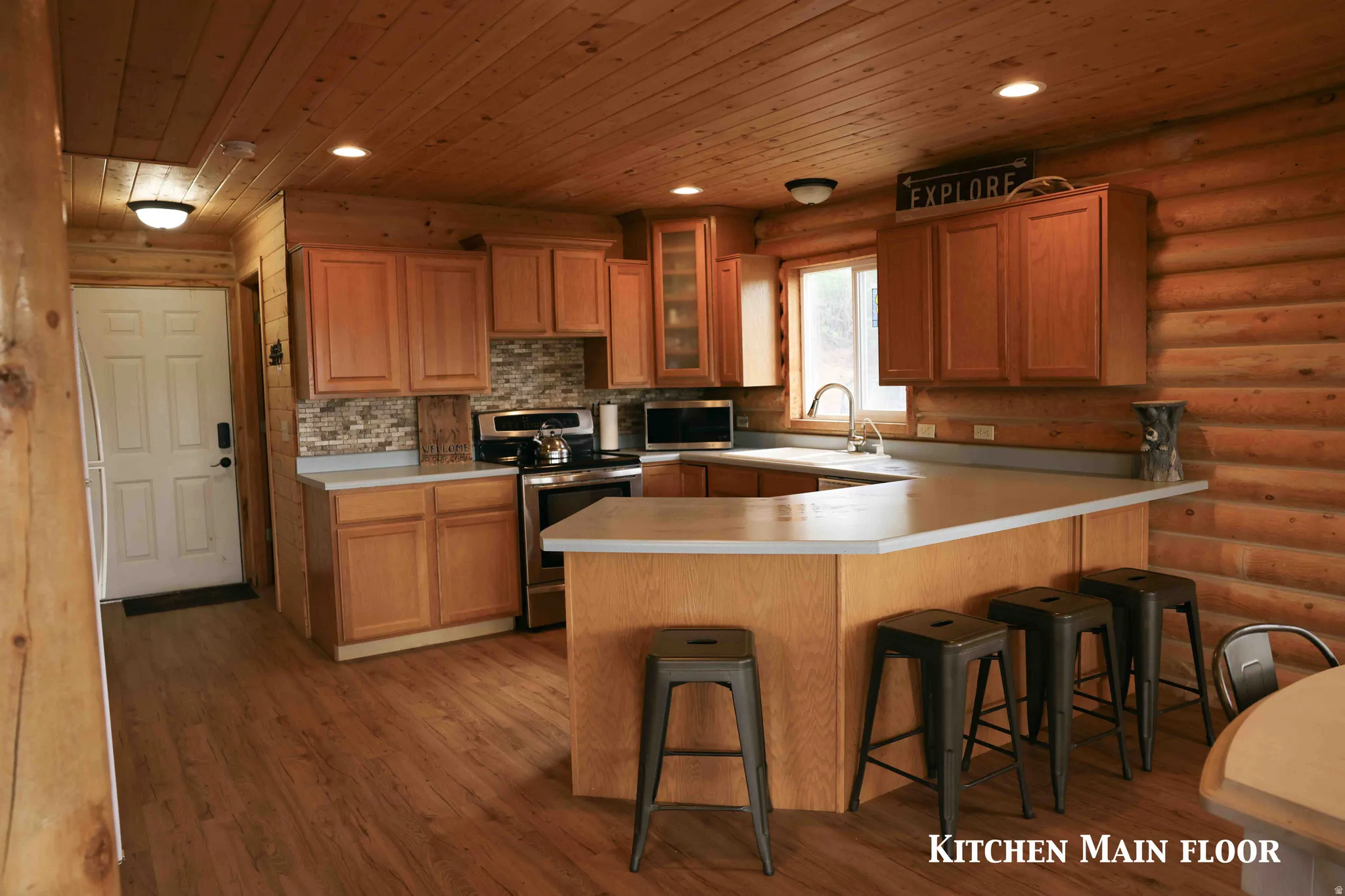 Kitchen featuring wood-finish flooring, wood plank ceiling, and log wall construction