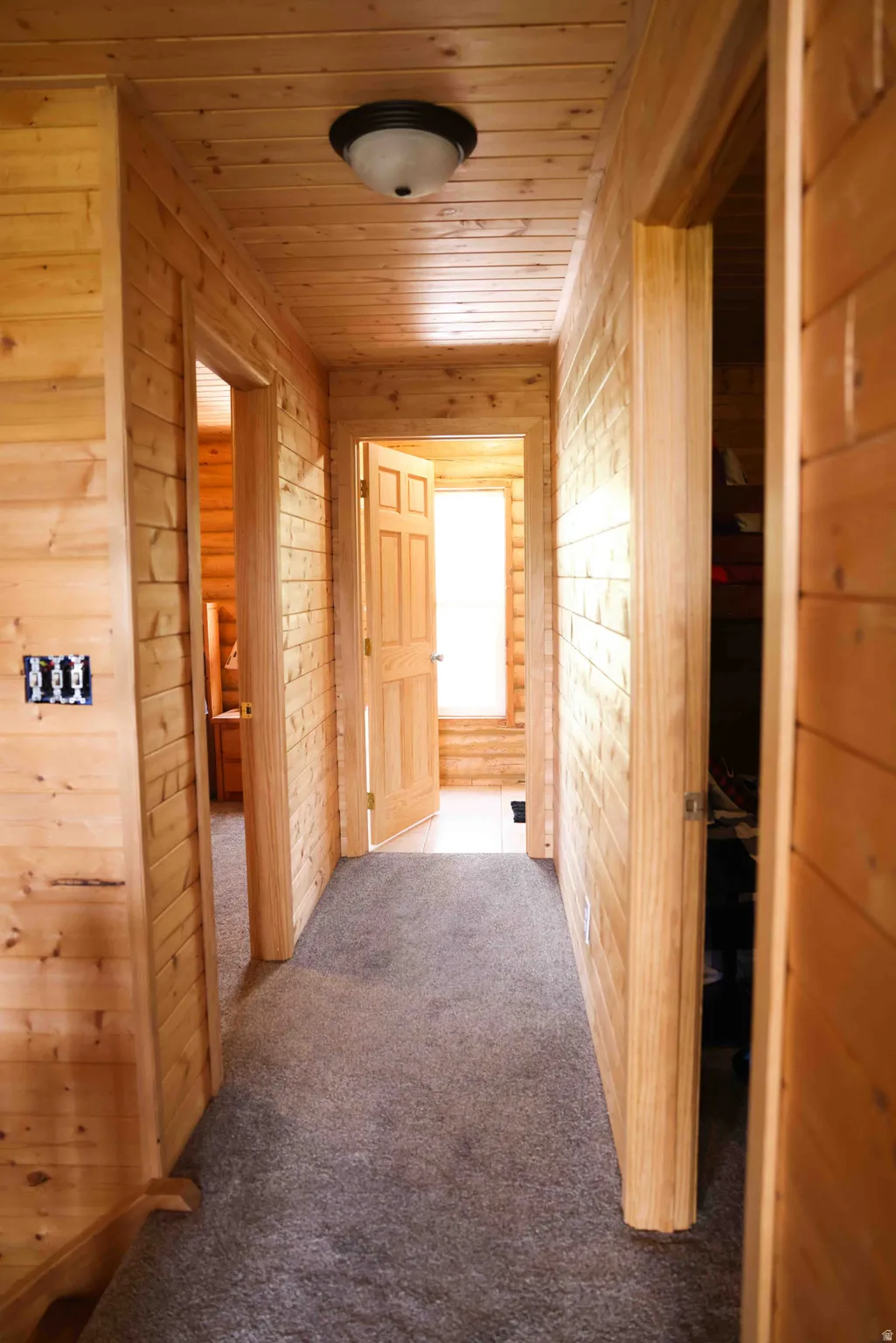 Wood-paneled hallway featuring matching wood doors and trim