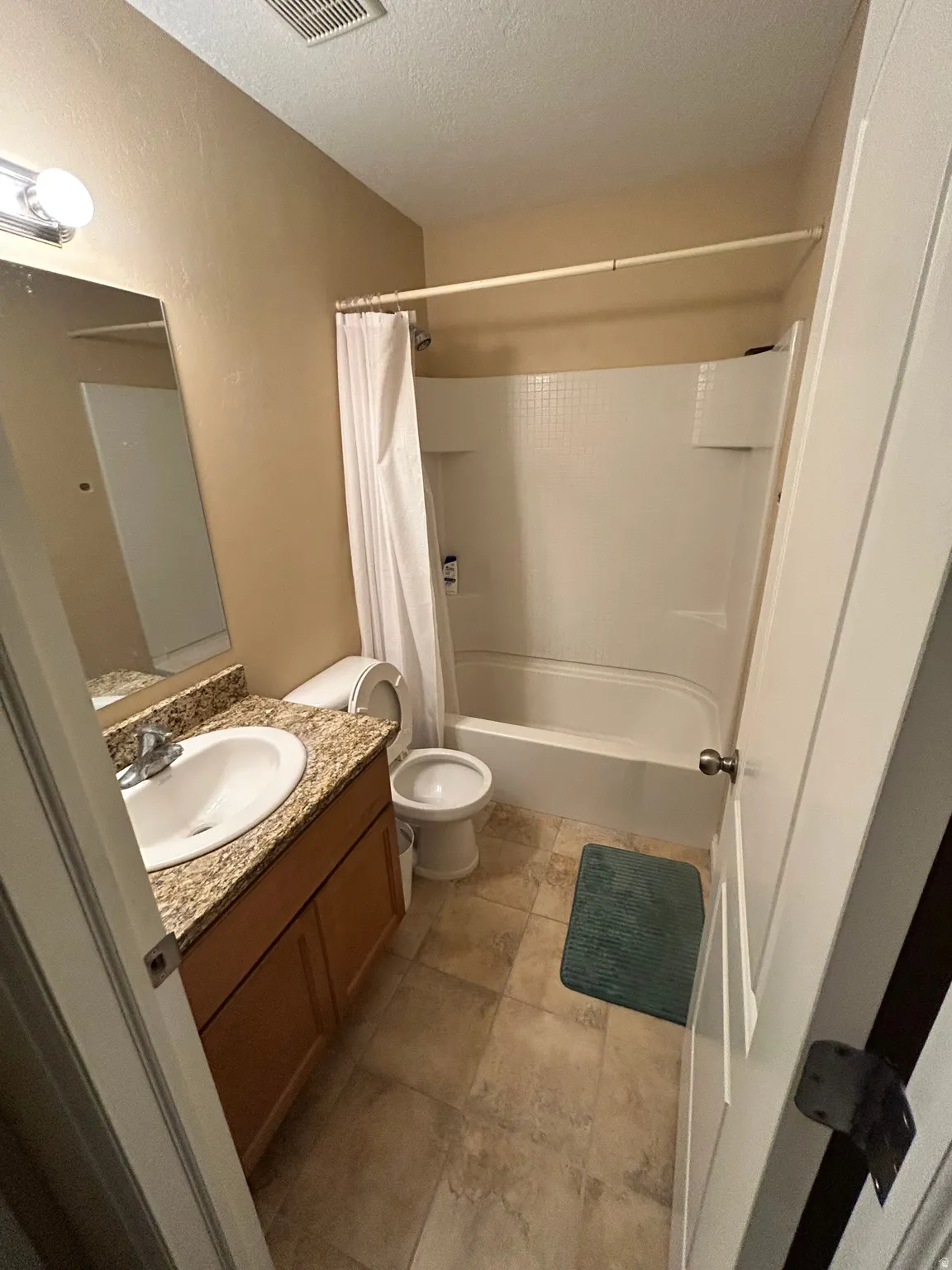 Bathroom featuring a single vanity, integrated sink, and wood-finish cabinetry