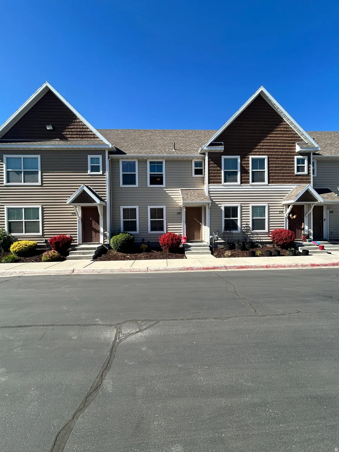 Two-story exterior with light-toned horizontal siding and dark brown shake accents
