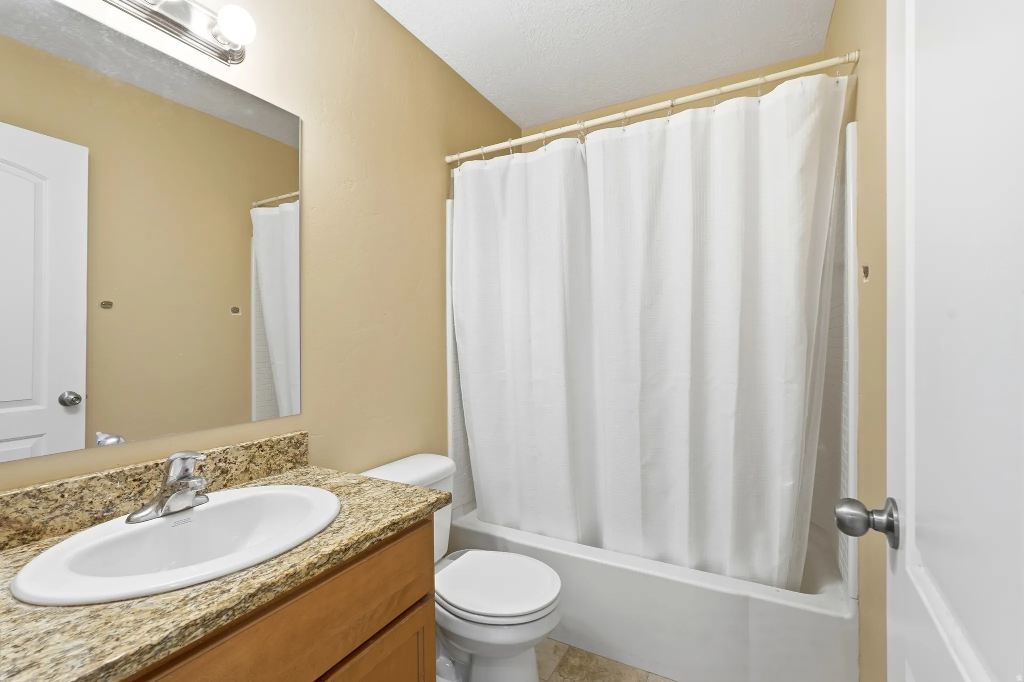 Upstairs full bathroom with rectangular mirror and stainless steel faucet