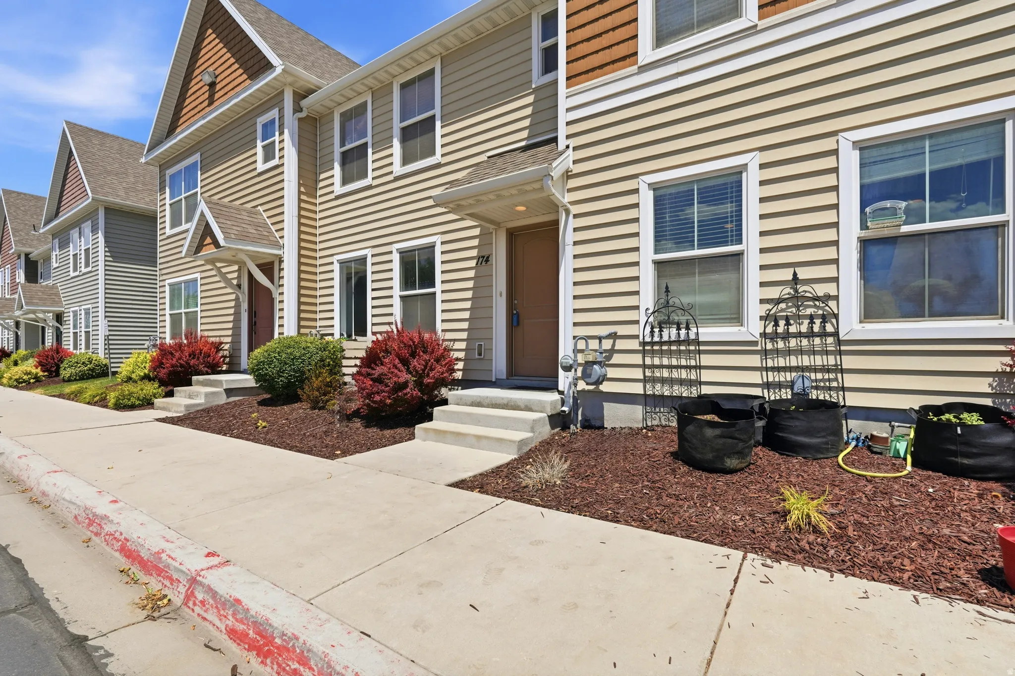 Townhome exterior featuring horizontal siding and gabled rooflines