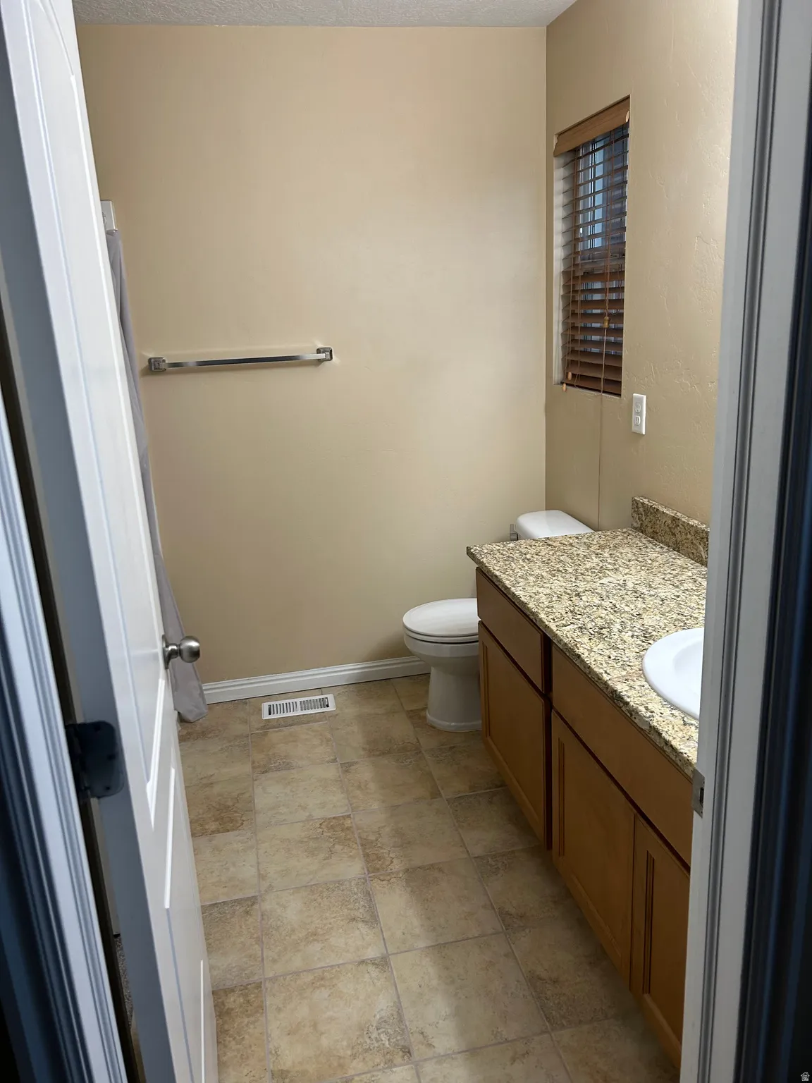 Master bathroom and vanity with a speckled countertop and integrated white sink