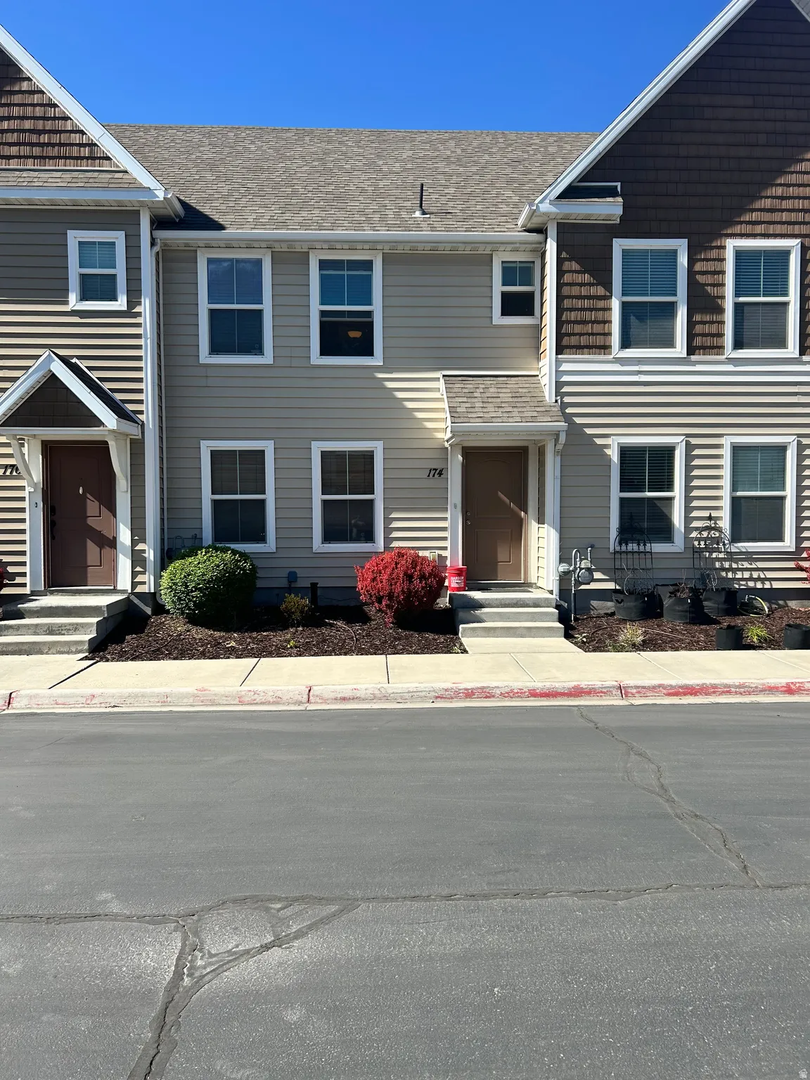 Two-story exterior with light-toned horizontal siding and dark brown shake accents