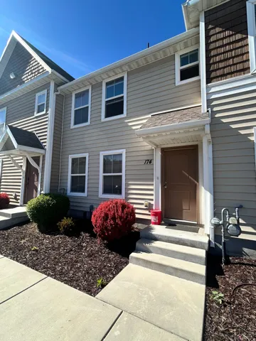 Two-story exterior with light-toned horizontal siding and dark brown shake accents
