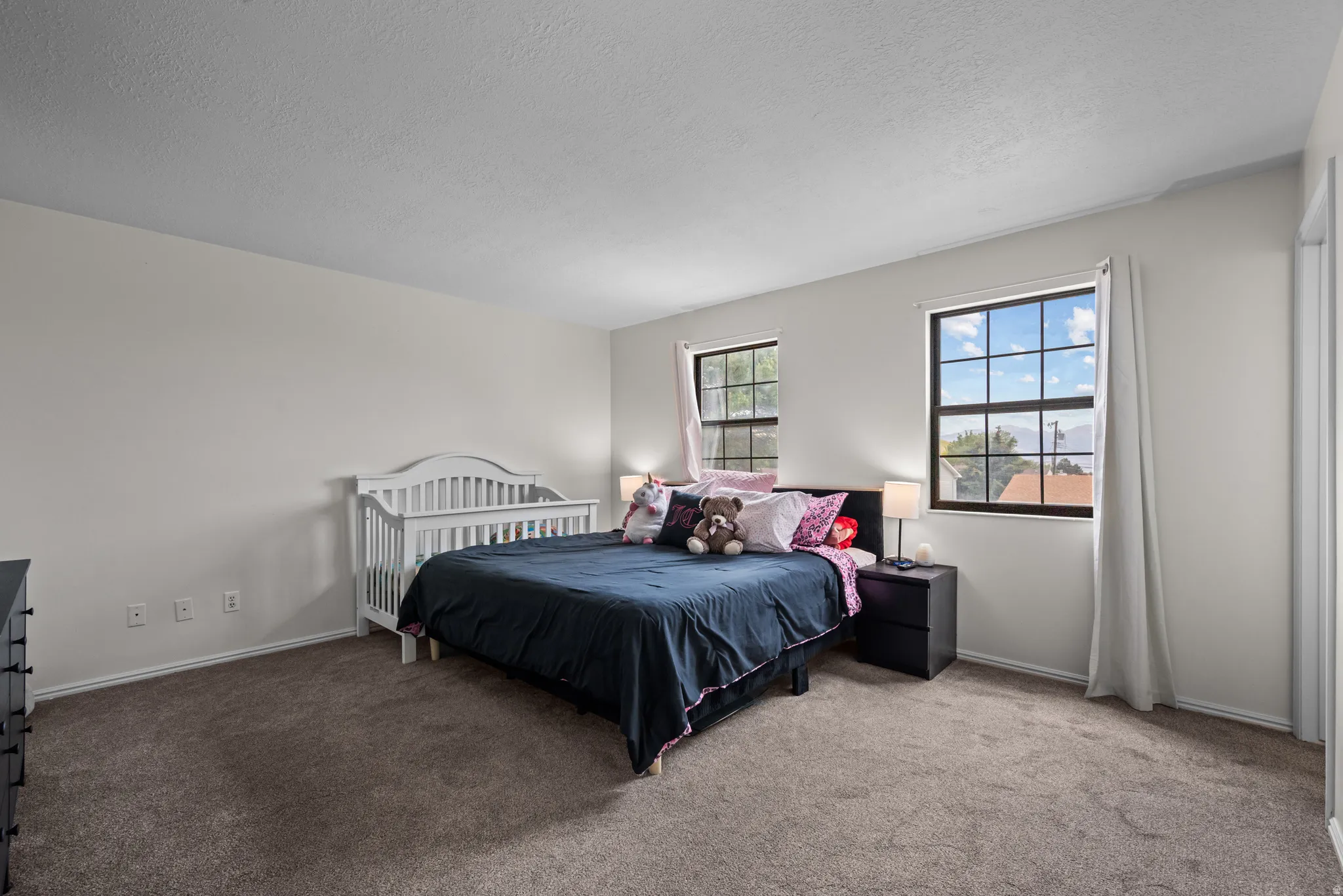 Spacious room featuring neutral carpeting and light-toned walls