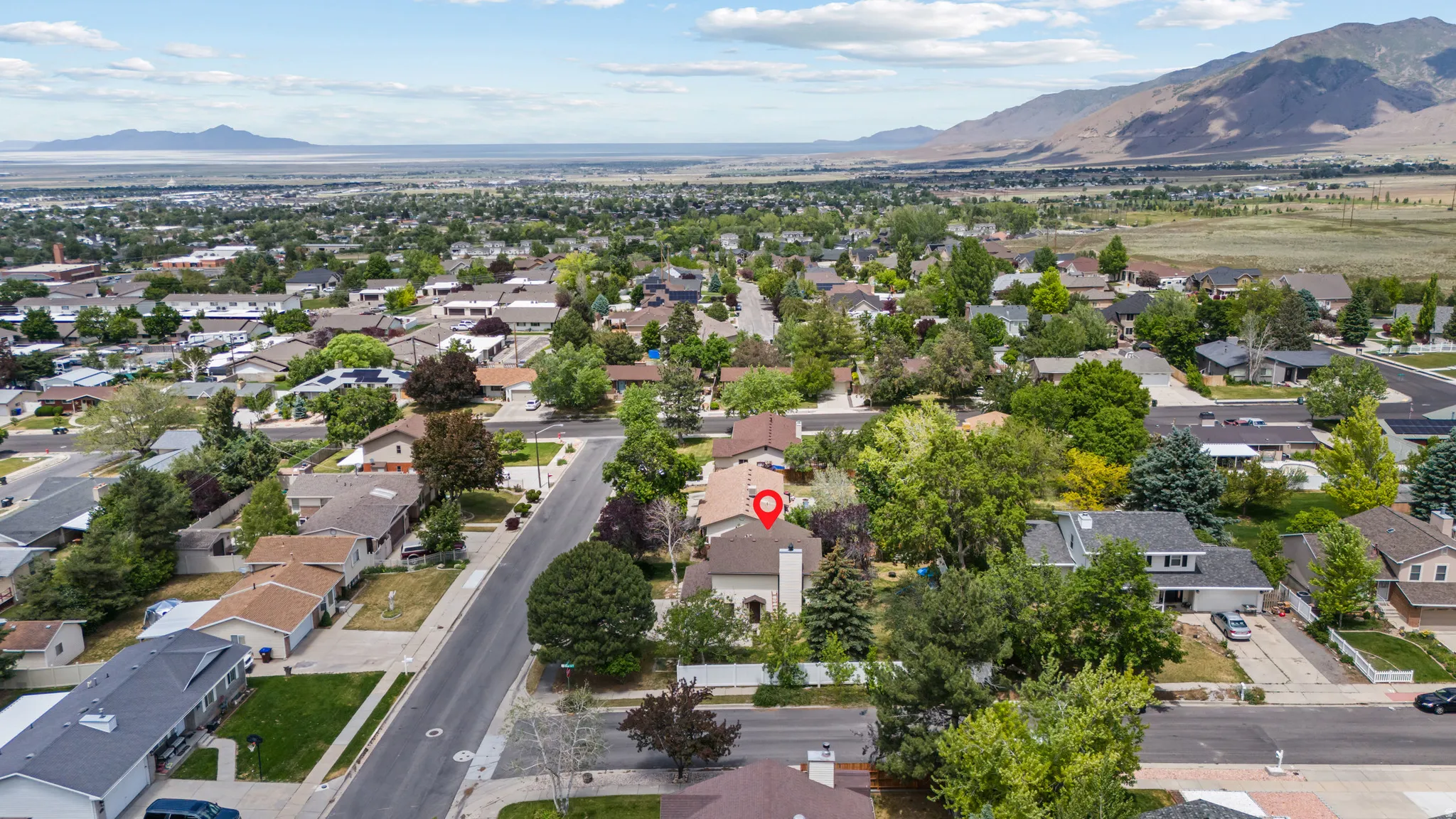 Aerial perspective showcasing a residential neighborhood with a prominent mountain range in the background
