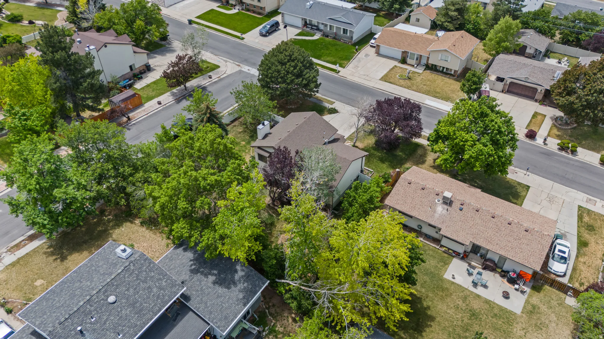 Residential property featuring a shingle roof and a paved driveway