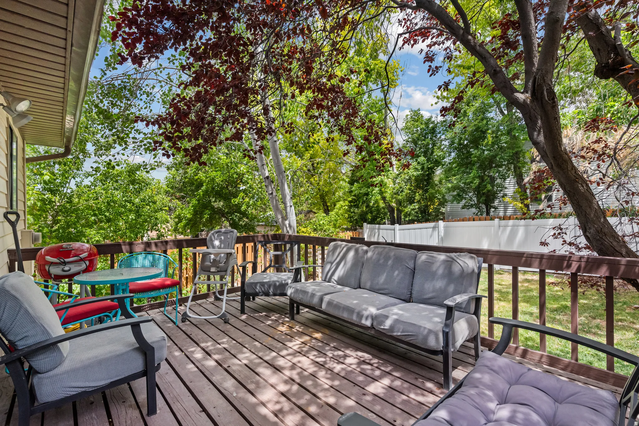 Spacious outdoor deck featuring wood-finish flooring and dark wood railing