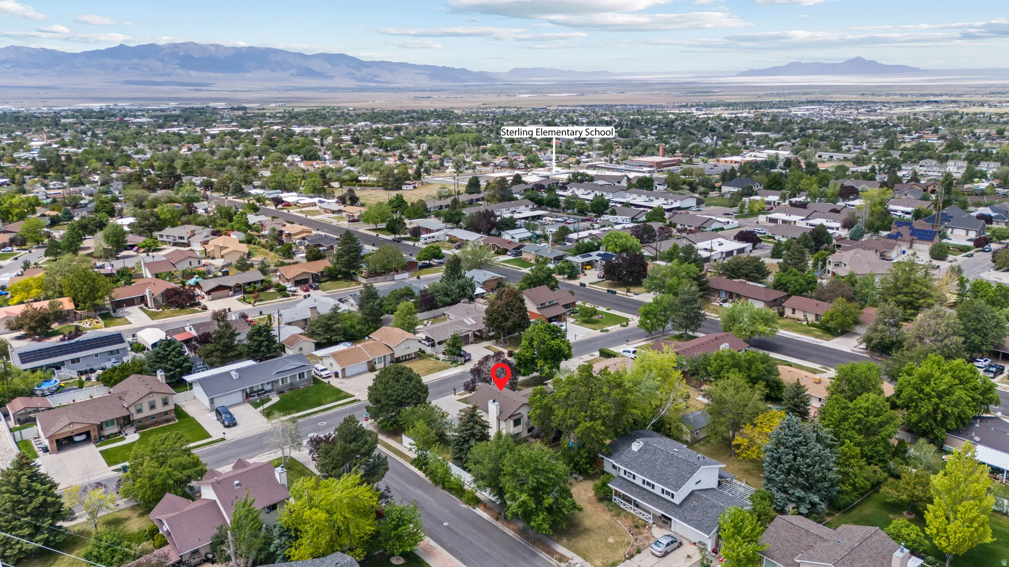 Expansive aerial view of a residential neighborhood with a mountainous backdrop