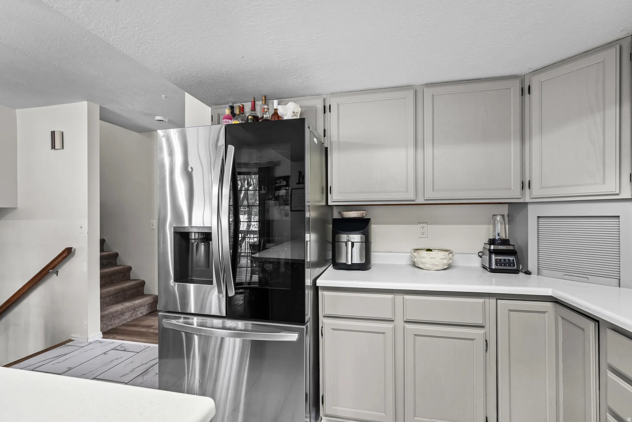 Kitchen featuring light gray cabinetry and white countertops