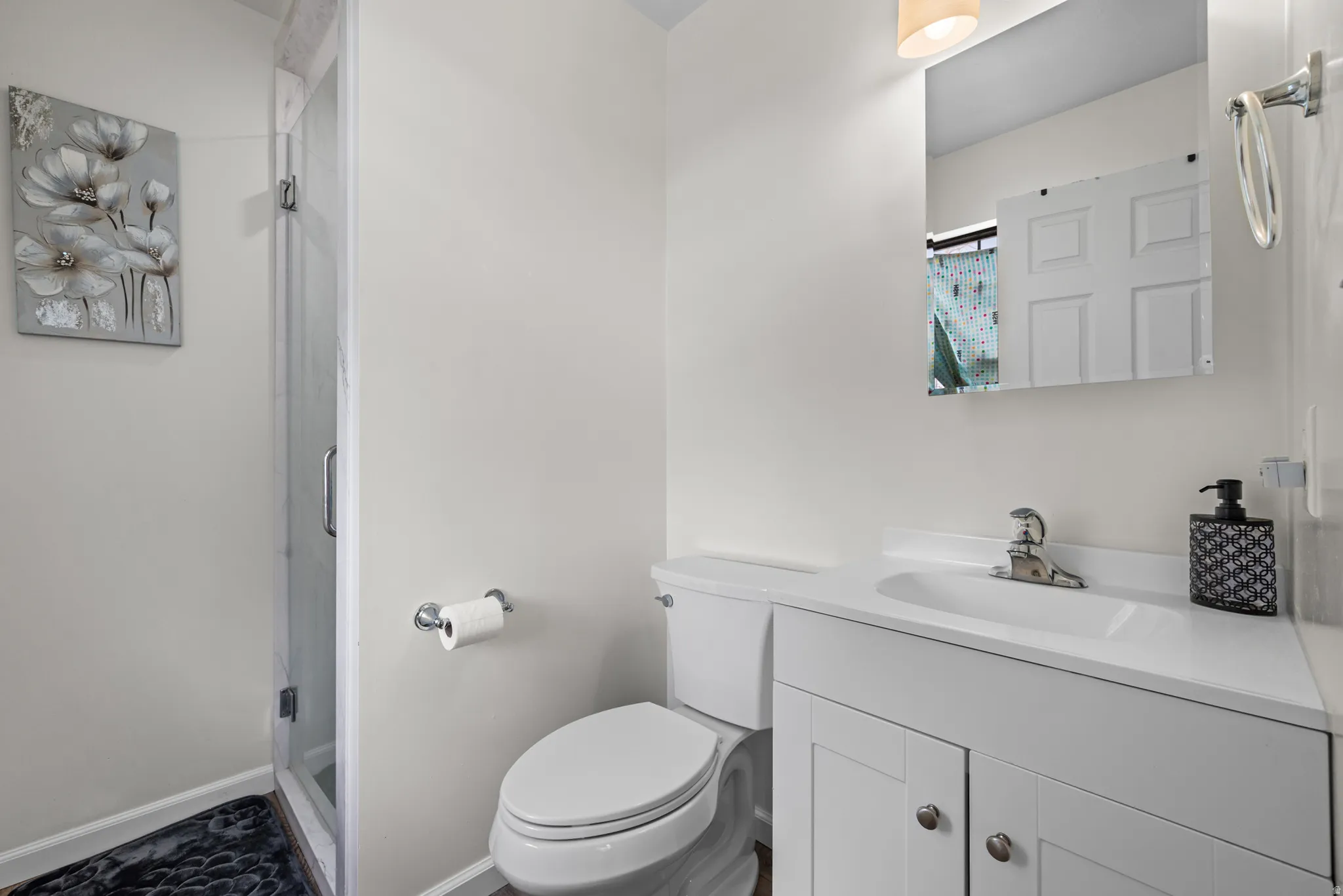 White vanity with integrated sink and chrome faucet, set against white walls