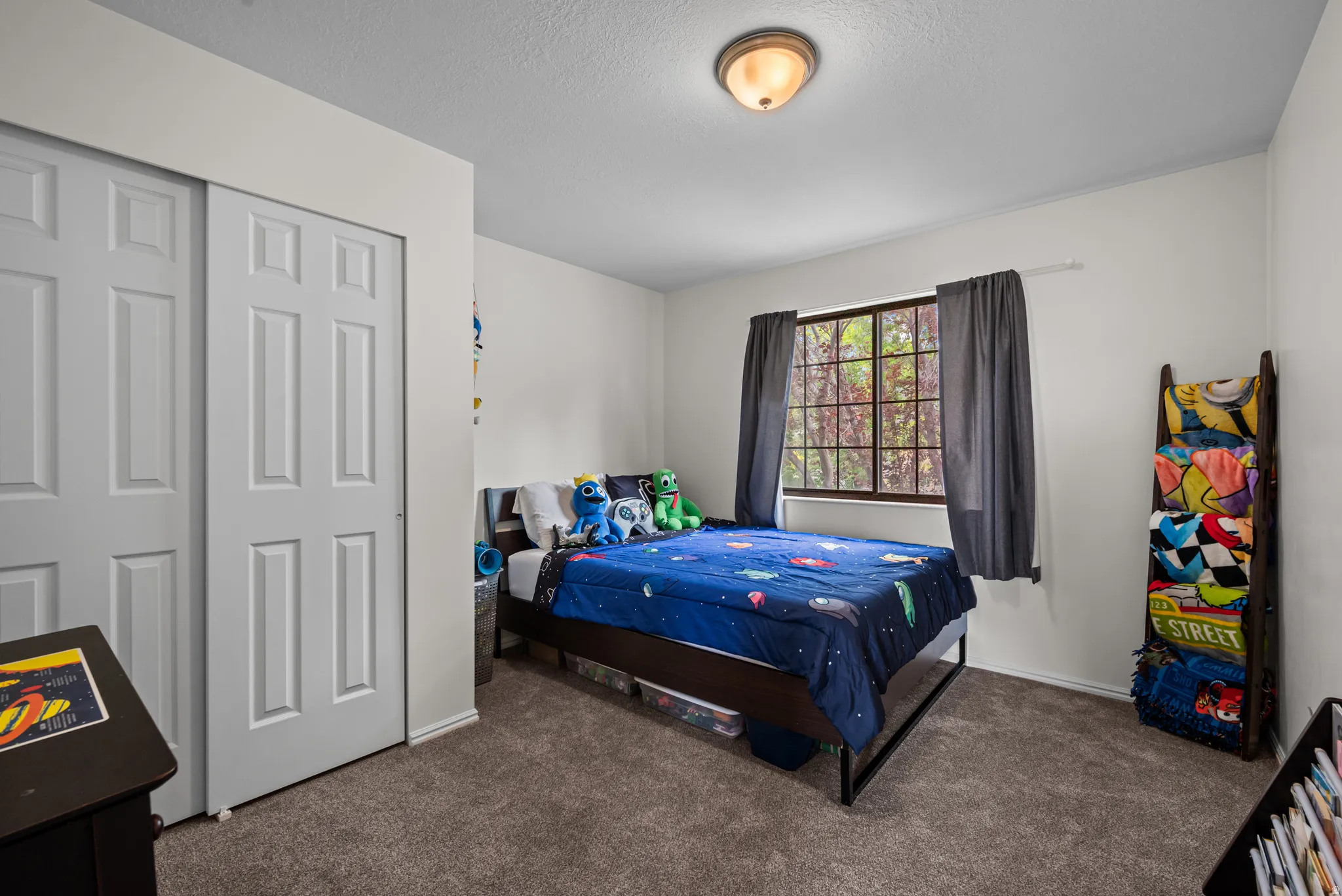 Carpeted room with a double-pane window, flush-mount ceiling light, and bi-fold closet doors