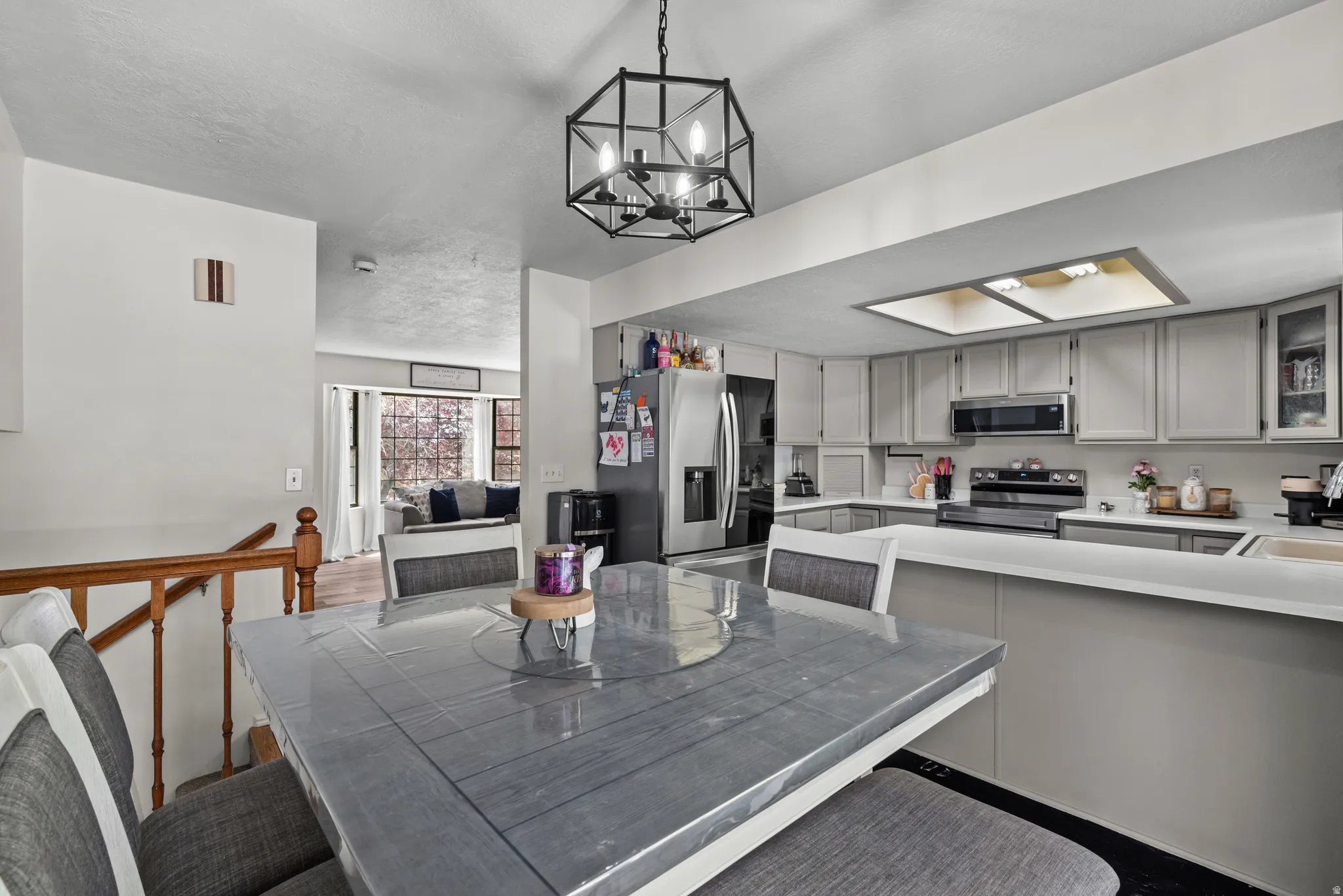 Kitchen featuring light gray cabinetry, stainless steel appliances, and white countertops