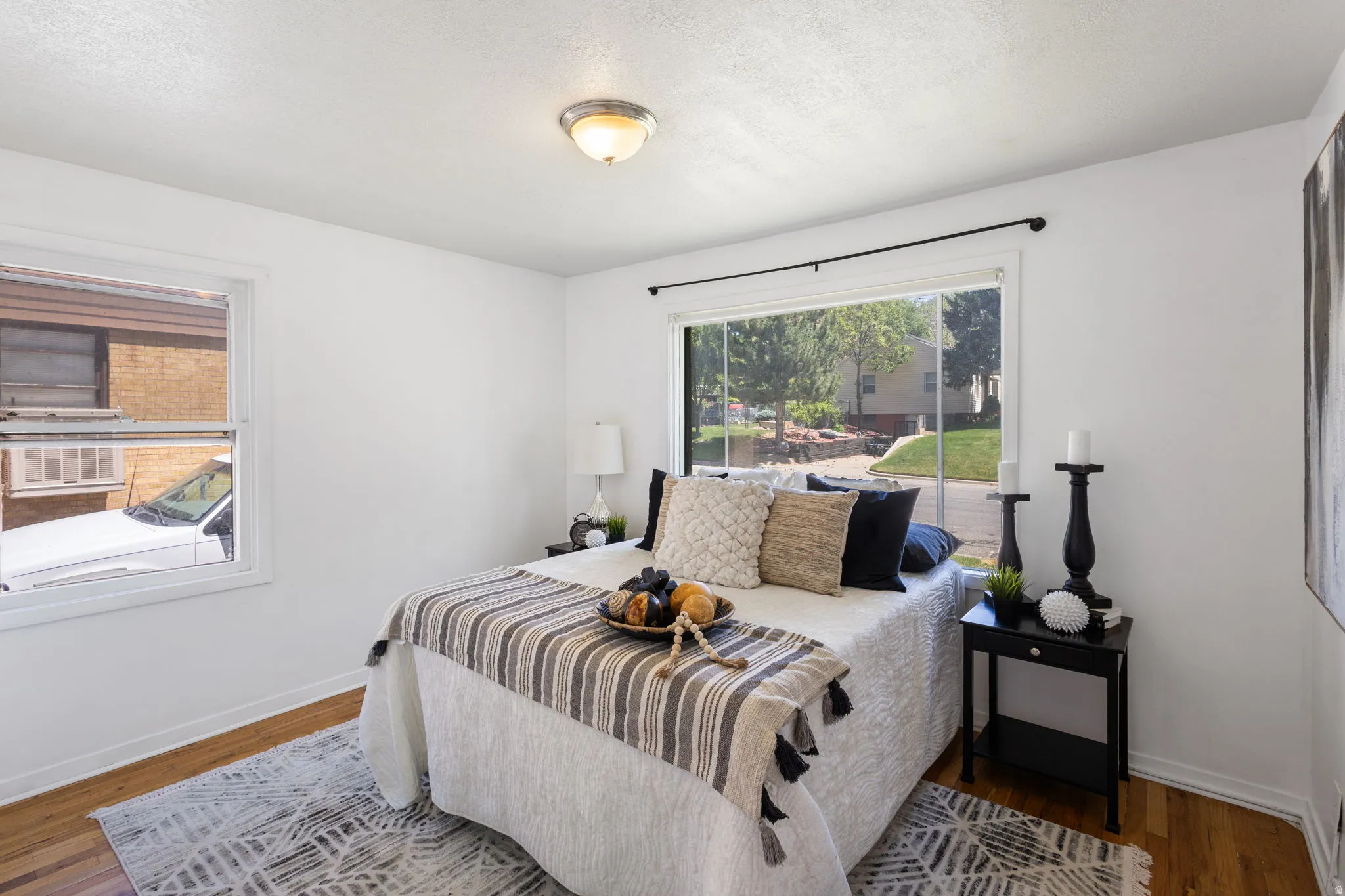 Bedroom featuring hardwood flooring, white baseboards, and a flush-mount ceiling light