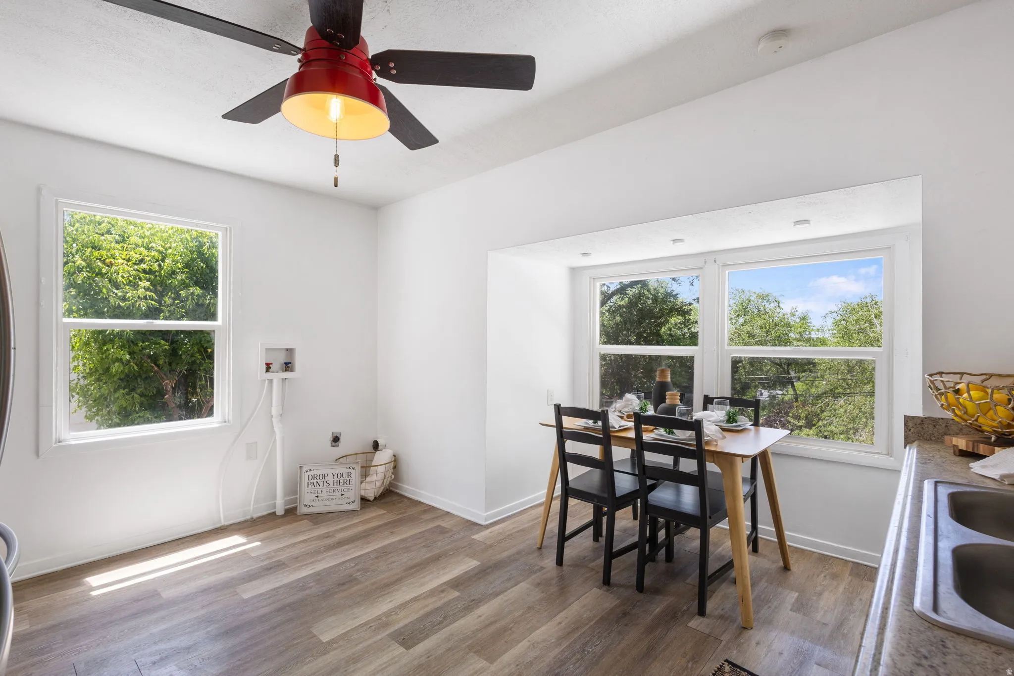 Bright dining area featuring LVP flooring, multiple large windows, and a built-in countertop extension