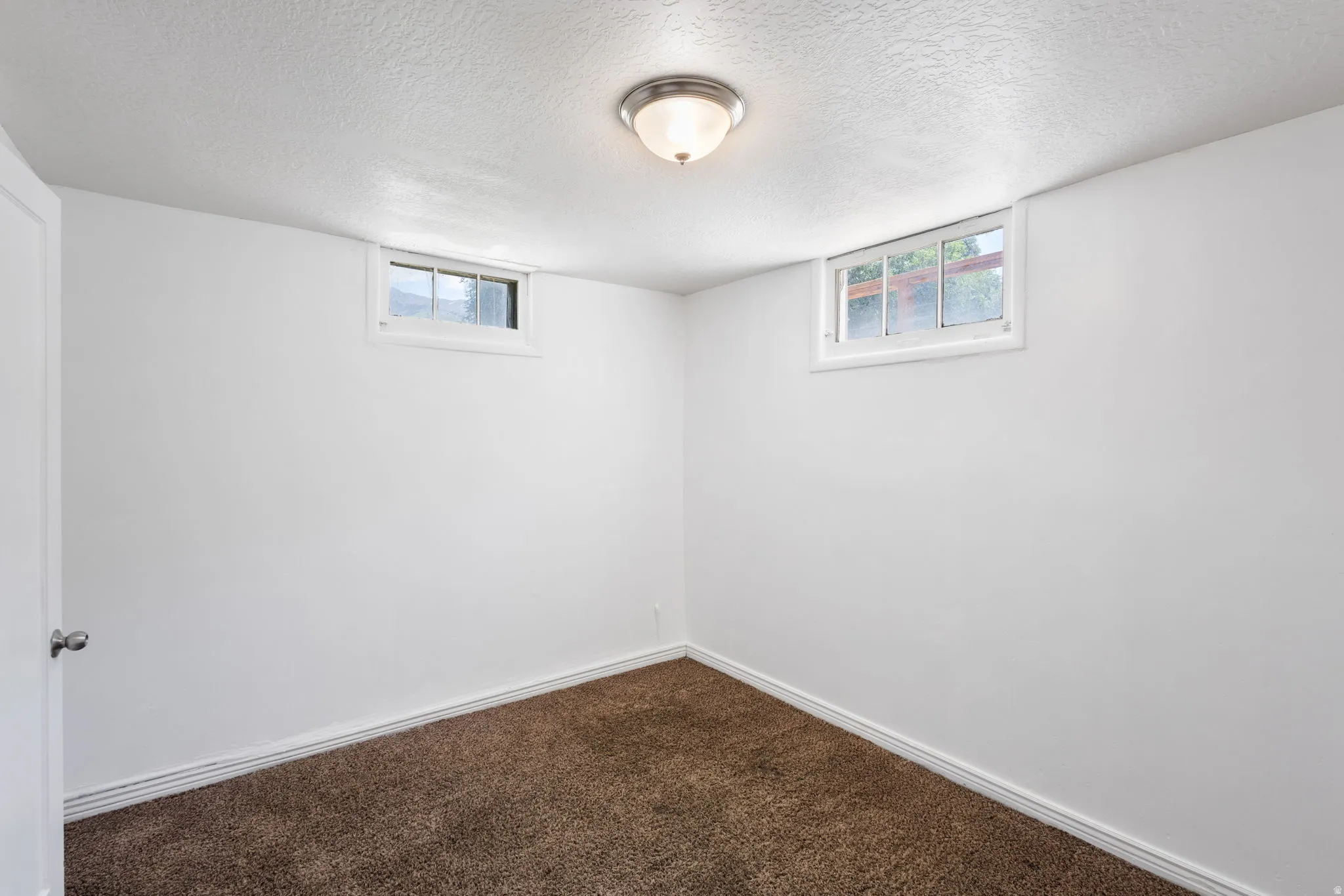 Neutral white walls and textured ceiling with a flush-mount light fixture