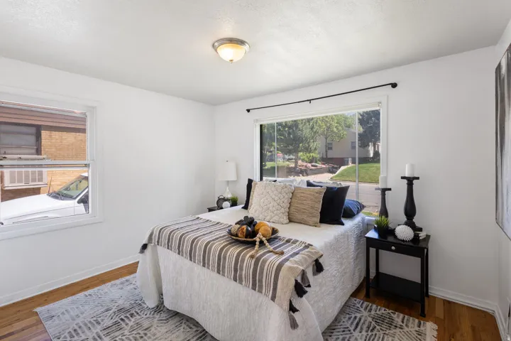 Bedroom featuring hardwood flooring, white baseboards, and a flush-mount ceiling light
