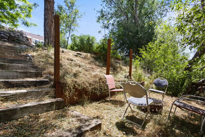 Terraced outdoor area featuring natural wood retaining walls and stair treads