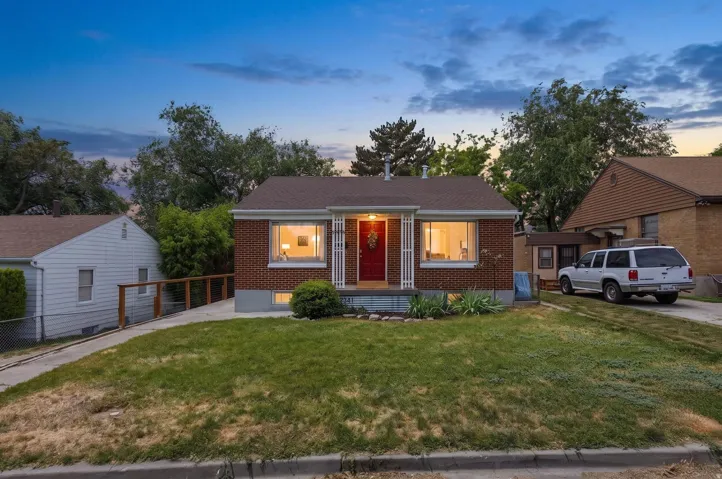 Brick-clad residence featuring a red front door and a covered front porch.