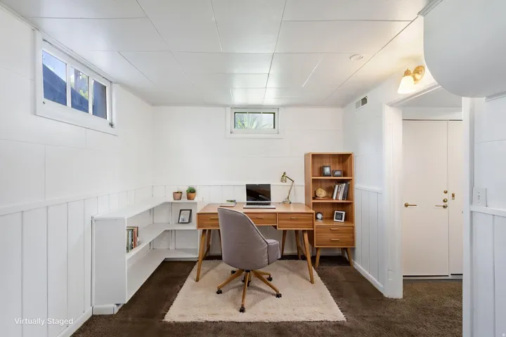 Room featuring built-in shelving, white paneled walls, and carpet flooring, virtually staged