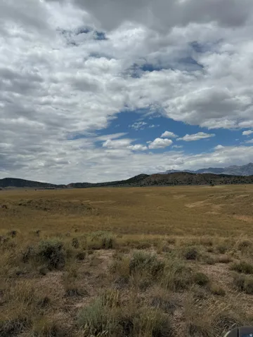 Expansive open land featuring diverse vegetation and rolling terrain