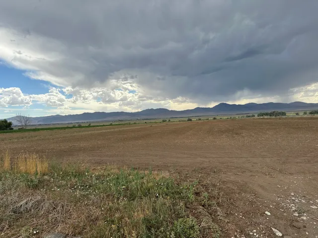 Expansive tilled agricultural land with distant mountain ranges and open sky
