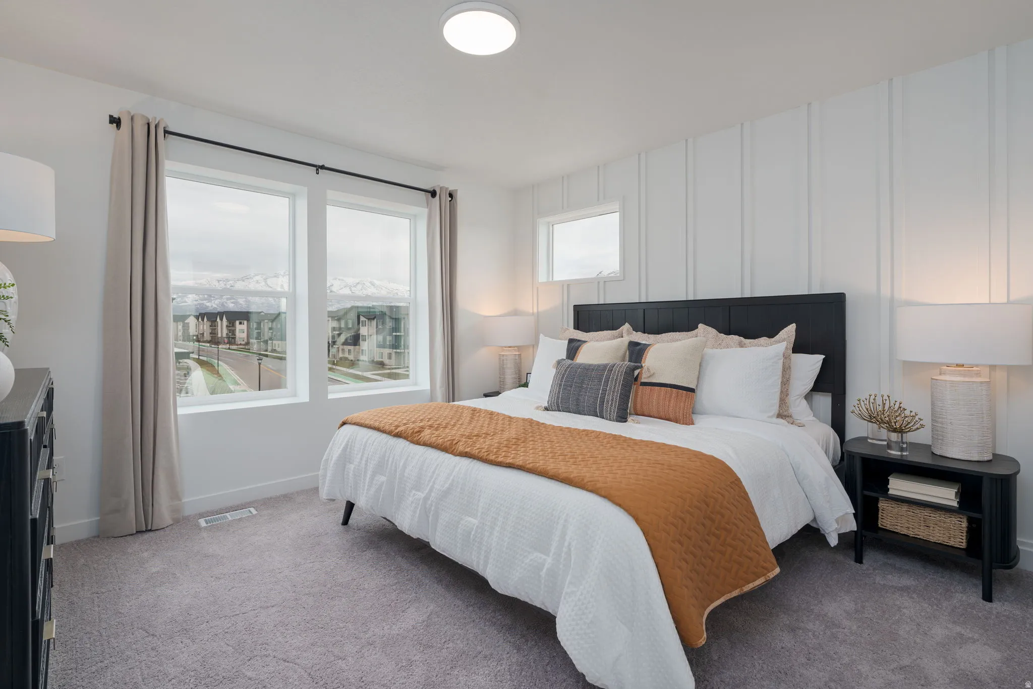 Interior room featuring a textured accent wall, two large windows, and a smaller upper window