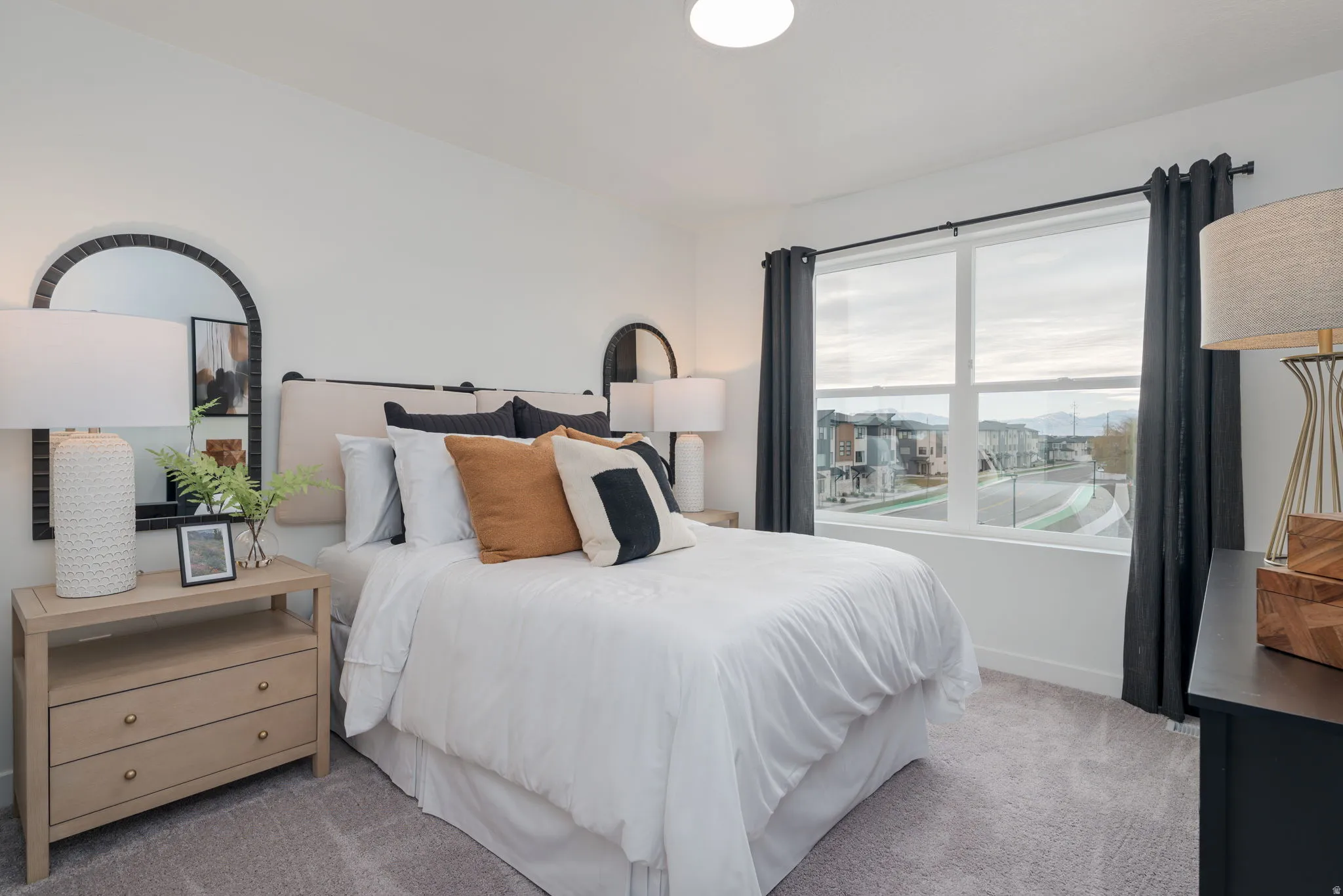 Spacious bedroom featuring plush carpeting, a large window, and a built-in overhead light fixture