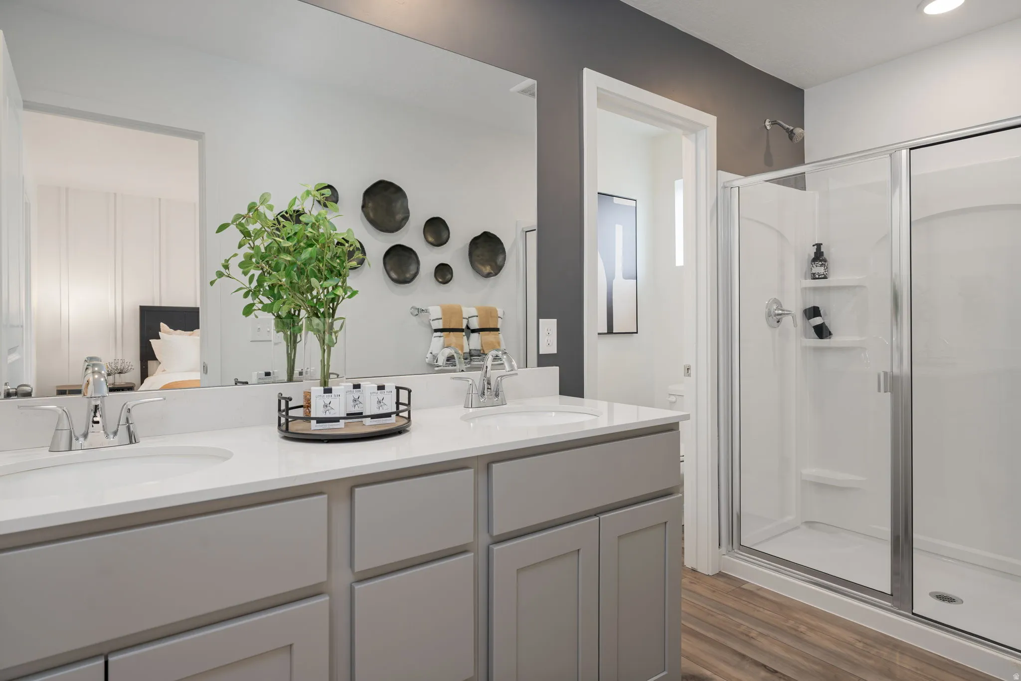 Dual vanity with undermount sinks, chrome faucets, and light gray cabinetry