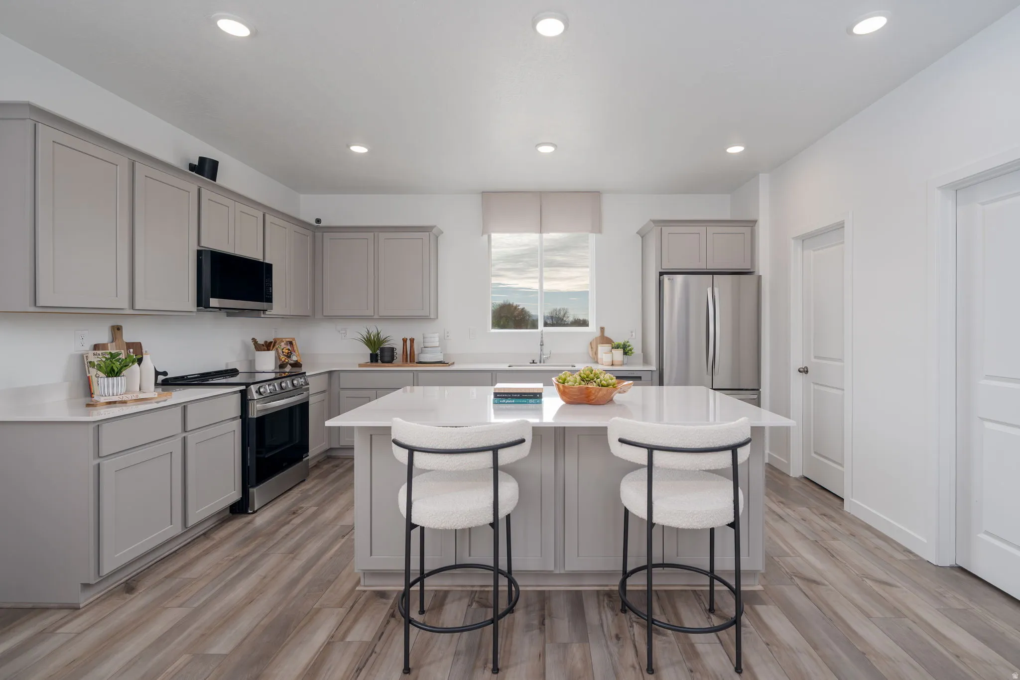 Contemporary kitchen featuring light gray cabinetry and wood-finish flooring
