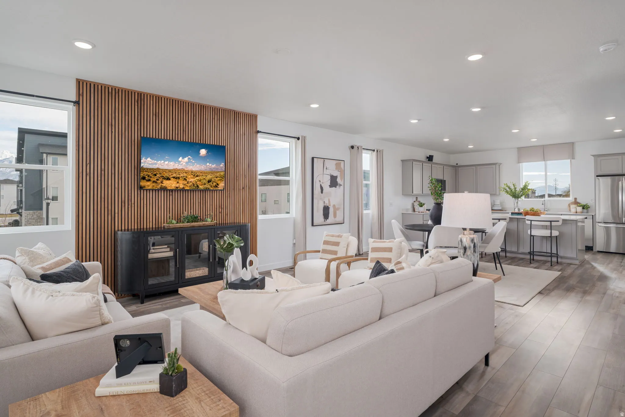 Open-concept living area featuring wood-finish flooring, recessed lighting, and a slatted accent wall