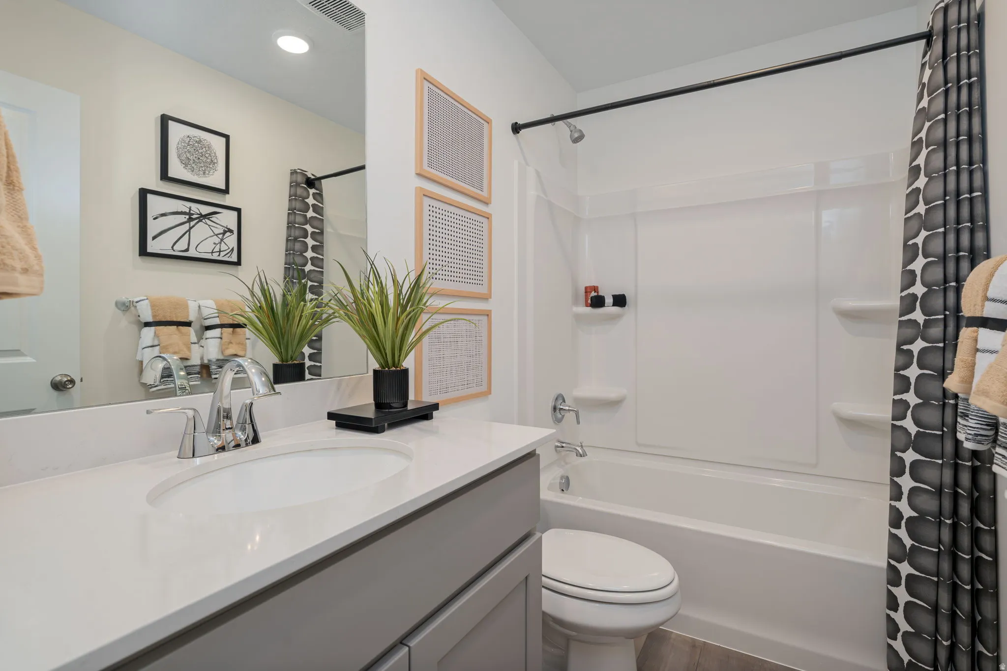 Bathroom featuring a single vanity with a white countertop, an undermount sink, and chrome fixtures