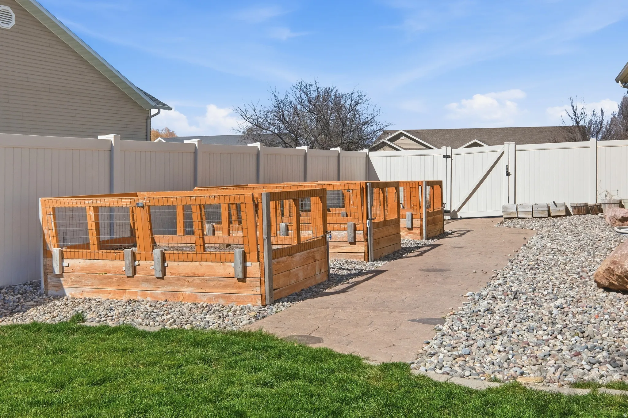 Outdoor area featuring multiple wooden raised garden beds with mesh tops