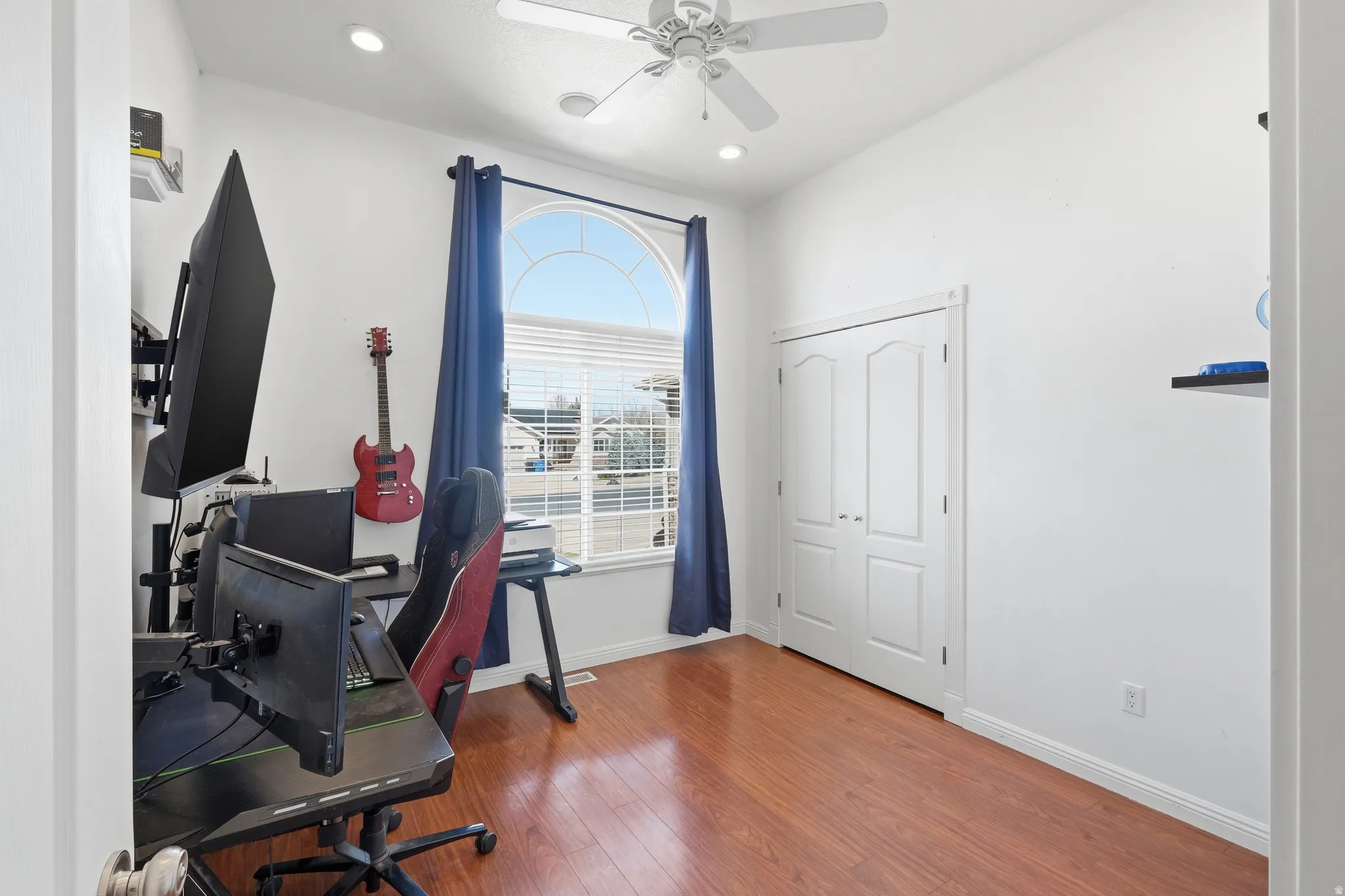 Room featuring wood-finish flooring, a vaulted ceiling, and recessed lighting