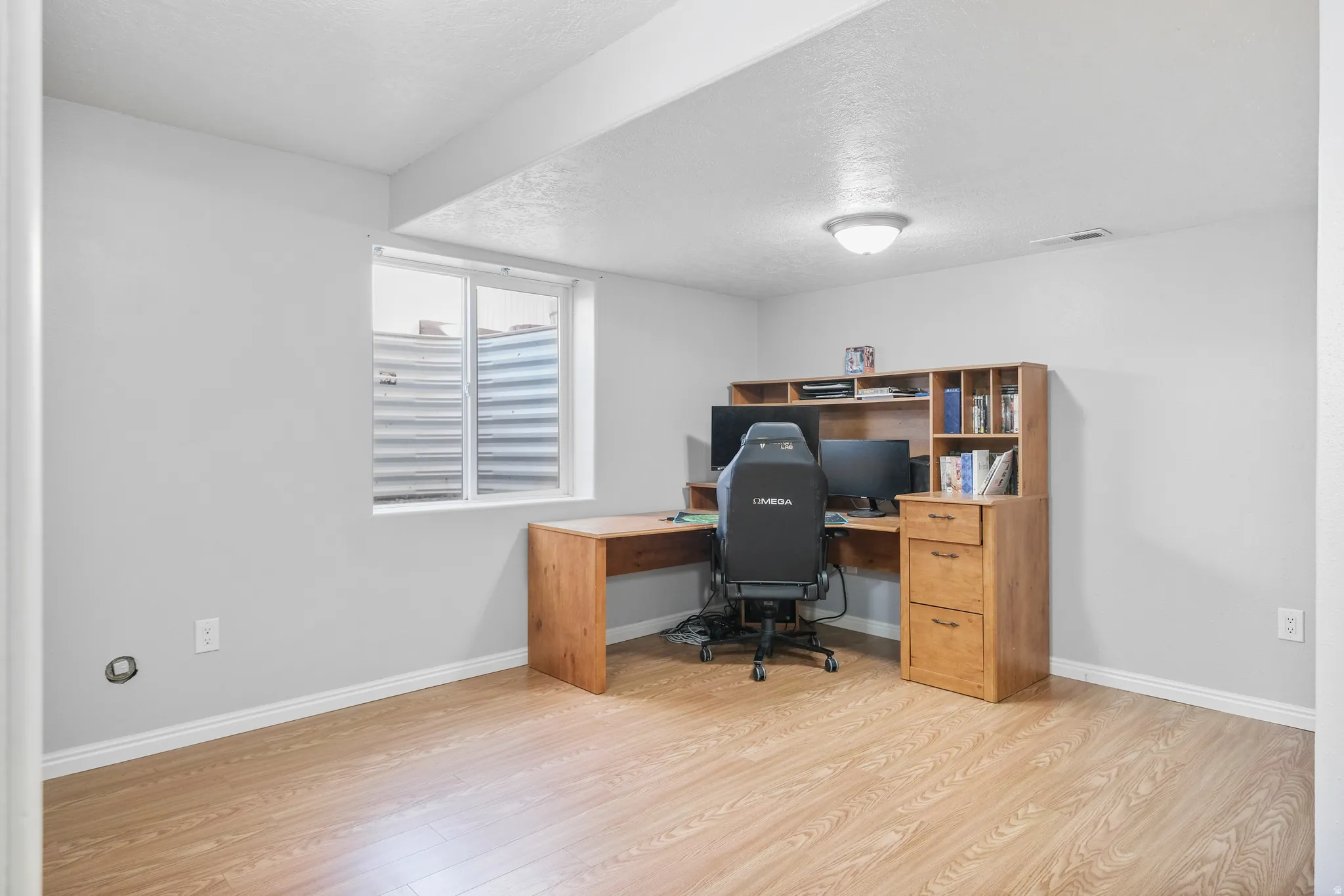 Room featuring wood-finish flooring, light grey painted walls, and white baseboards