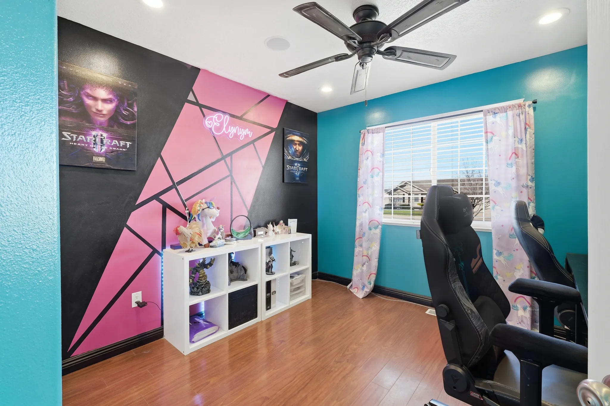 Room featuring wood-finish flooring and a ceiling fan with integrated lighting