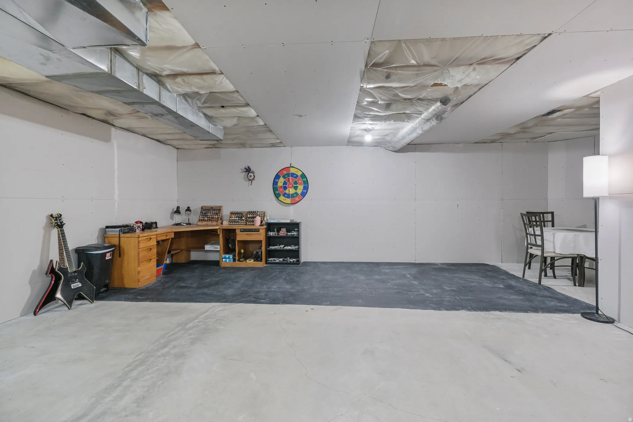 Expansive unfinished space featuring a concrete floor, white walls, and exposed ductwork