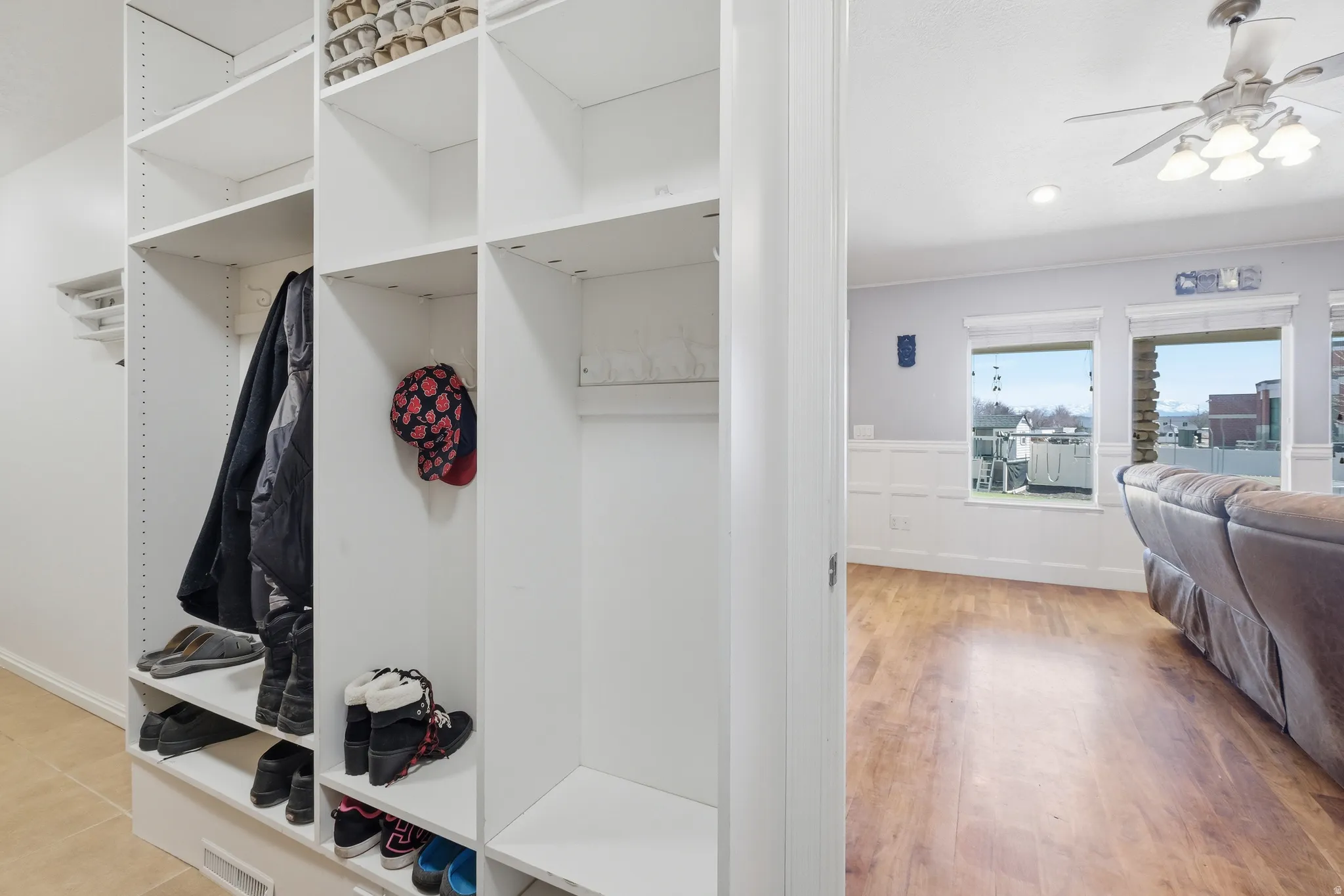 Built-in white shelving system featuring adjustable shelves and hanging rods