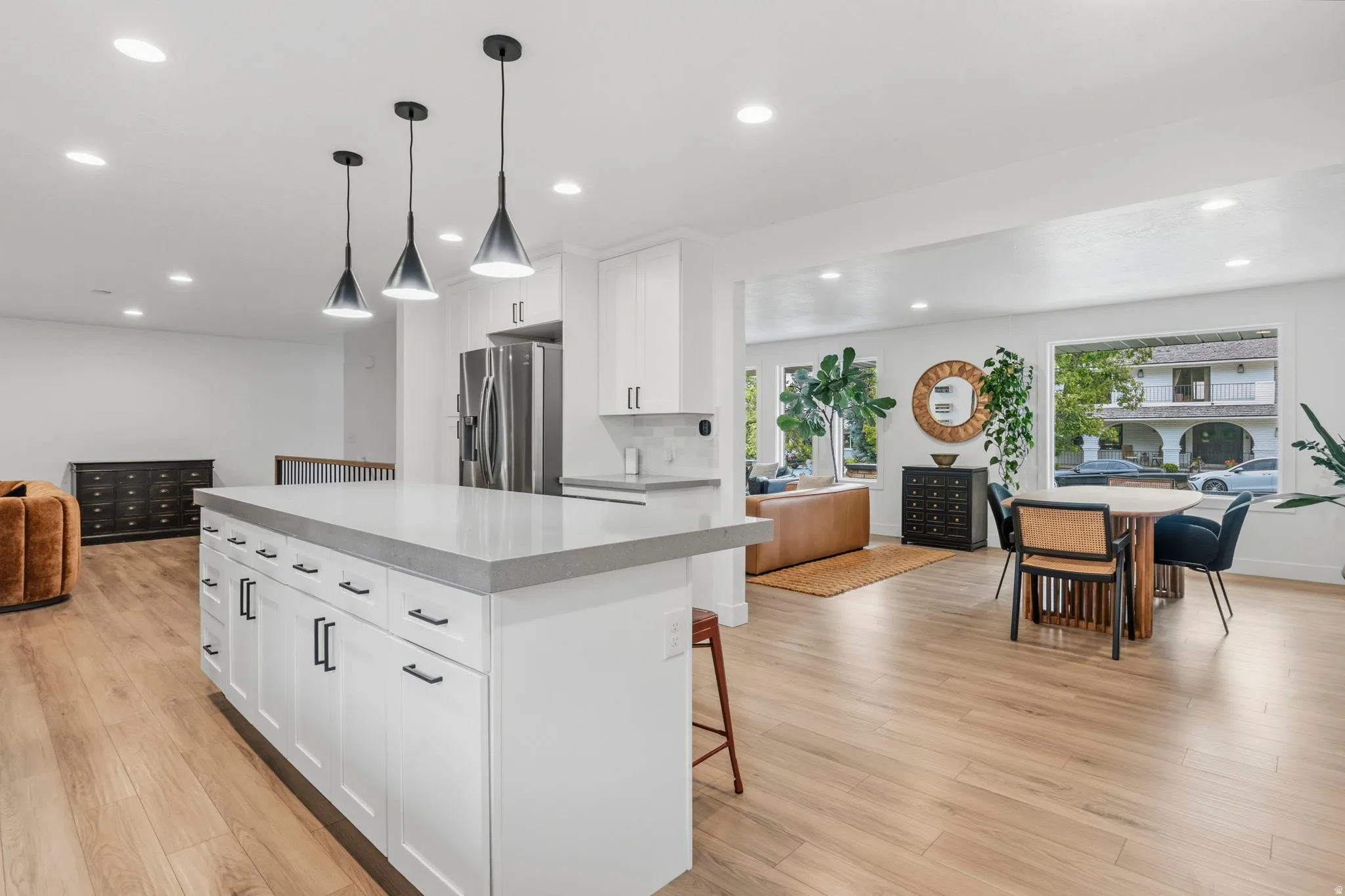 Spacious open-concept interior featuring light wood-finish flooring throughout
