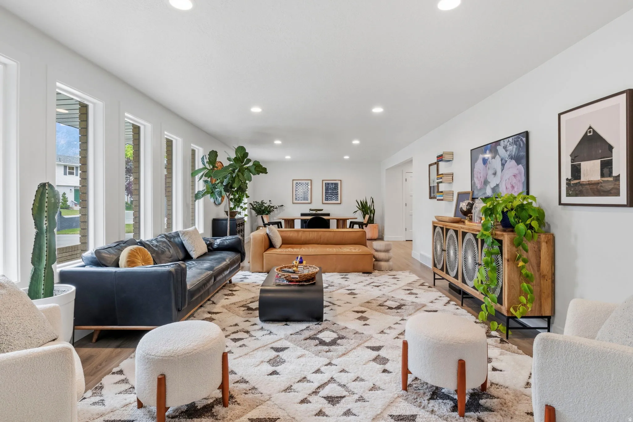 Spacious living area featuring multiple large windows, recessed lighting, and wood-finish flooring